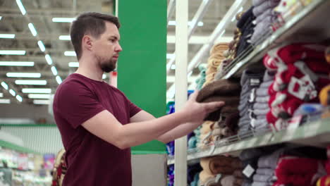 hombre comprando toallas en un supermercado