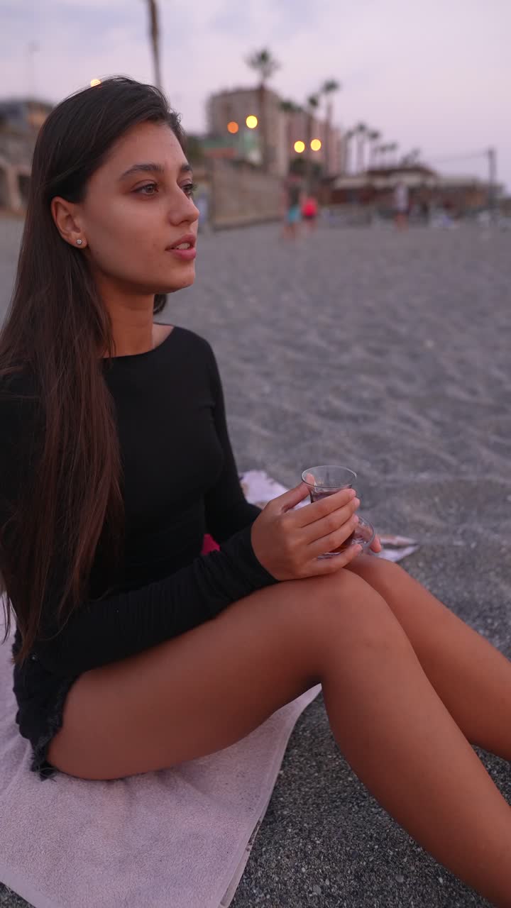 женщина наслаждается чаем на пляже на закате