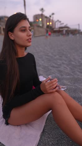 woman enjoying tea on the beach at sunset