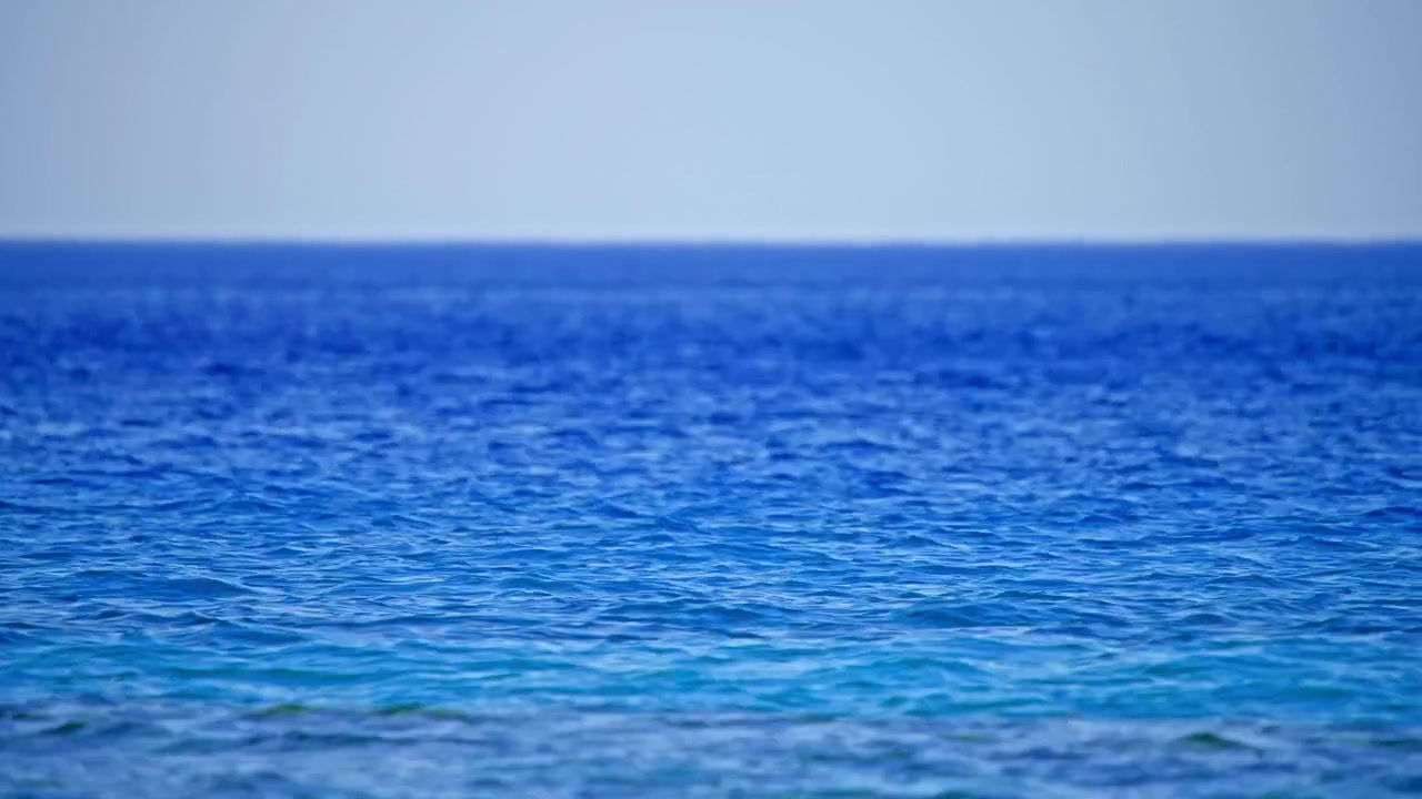 Rustig blauw oceaanoppervlak met zachte rimpelingen en horizon