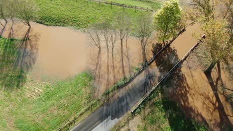 rising aerial of flood waters covering roadway in autumn