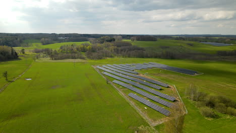 Hermoso-Vuelo-Aéreo-De-Drones-Sobre-Una-Granja-Solar-En-Campos-Rurales-Soleados-En-Polonia