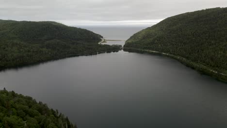 scenic view of calm lake by the green forest overlooking the saint lawrence gulf in gaspe, quebec, canada