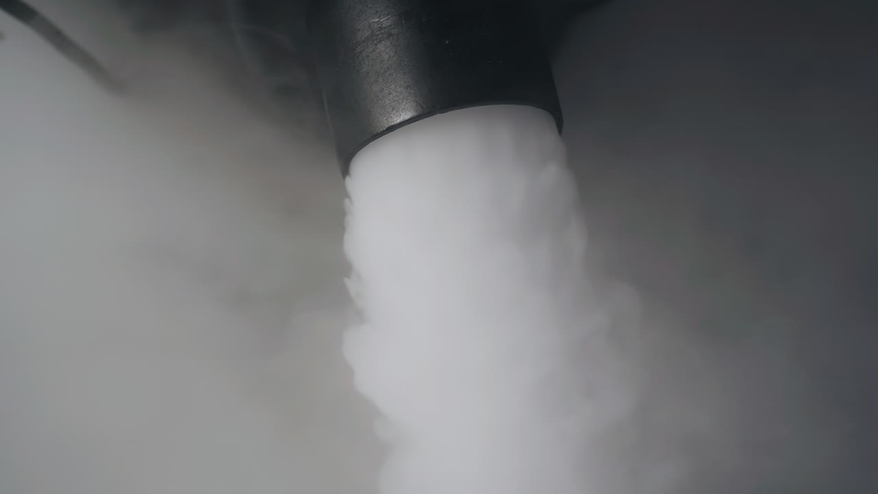 el proceso de funcionamiento de una máquina de humo en un evento de placer. una capa densa de humo está saliendo del dispositivo