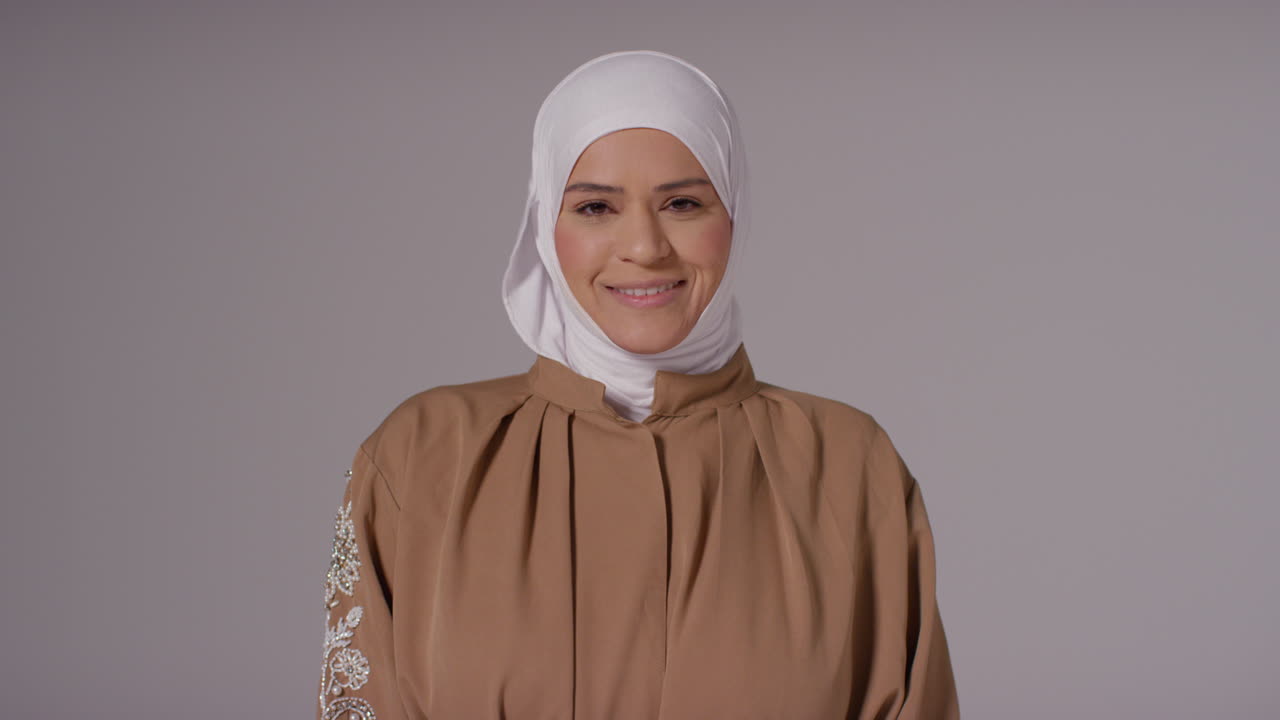 평평한 배경에 히자브를 입은 웃는 무슬림 여성의 스튜디오 초상화 4