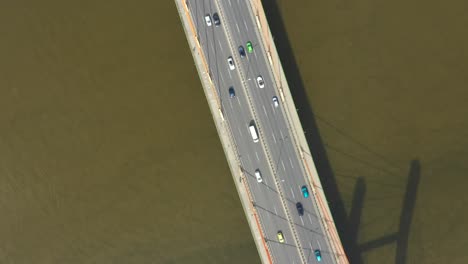 car traffic on hanging sea bridge over bay in city view from above