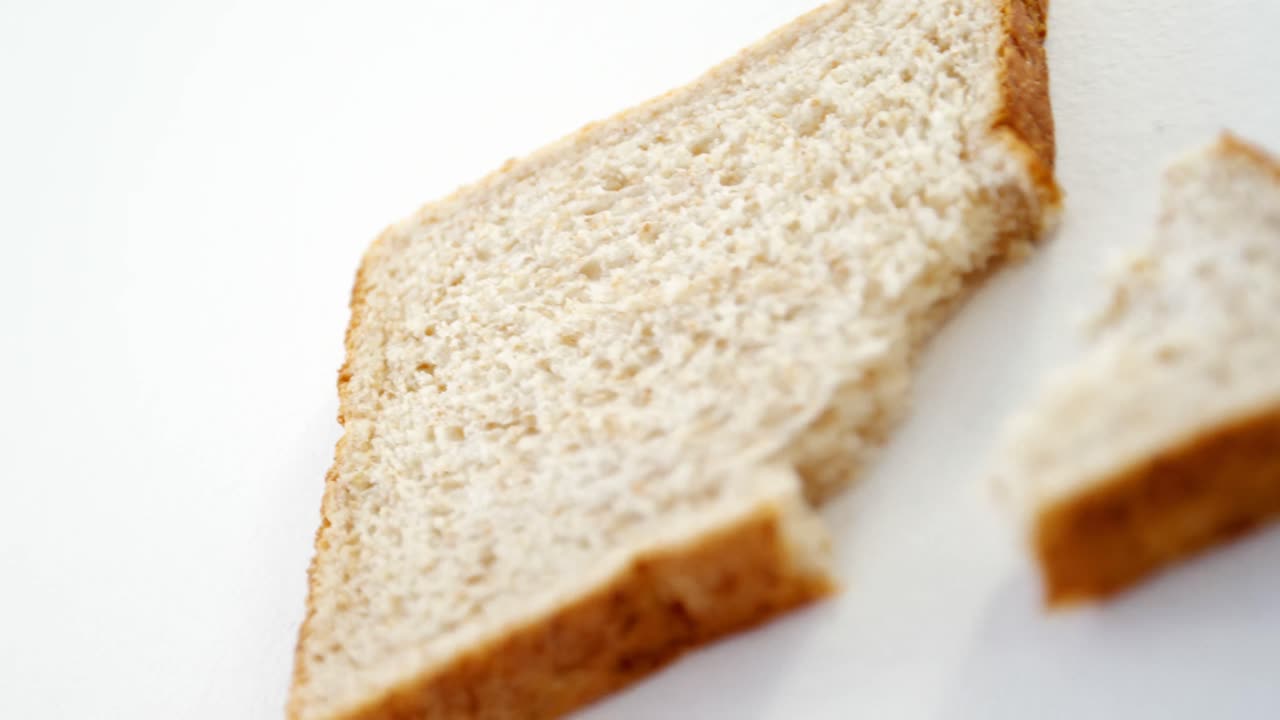 Bread slice with broken edge on white background