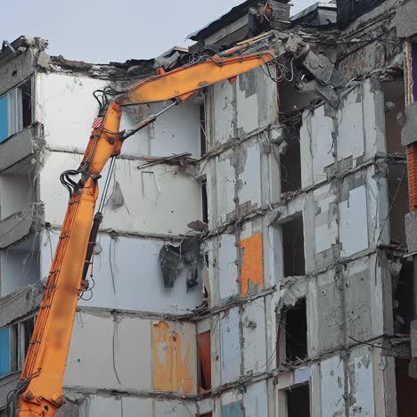 top floors destruction by the hydraulic claw of excavator. demolition of old house building for new construction by excavator bucket. view from the below