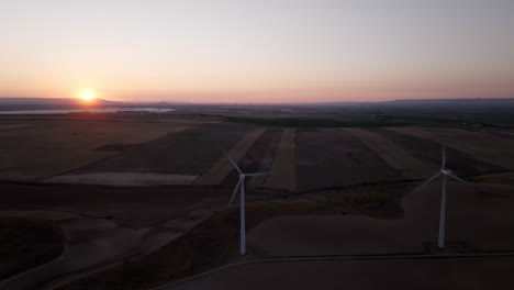 sunset over wind turbines and farmland