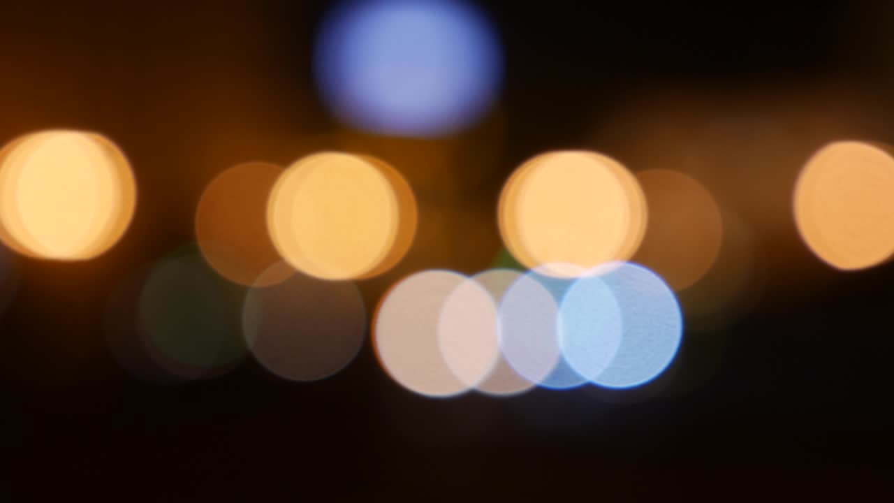 hermoso bokeh brillante en el fondo oscuro borroso por la noche. el redondo bokeh colorido brilla de las luces de los coches en la calle de la ciudad. fuera de foco con borroso. luces de la ciudad sin enfoque. bokeh de tráfico. concepto abstracto