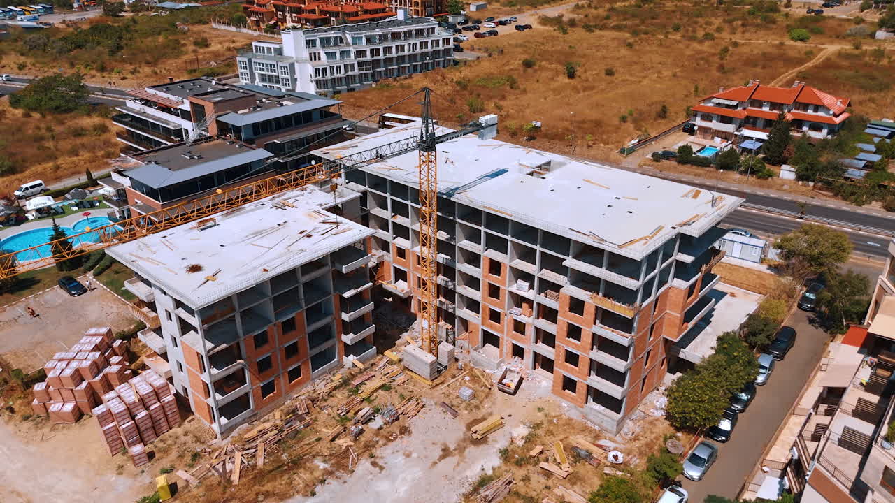 Seaside construction development. A large construction development with cranes and unfinished structures by the coast
