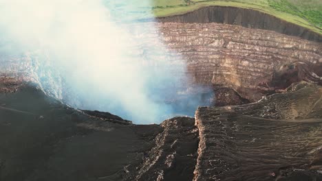 toma aérea cinematográfica sobre un cráter de volcán lleno de vapor de volcán en erupción en américa central