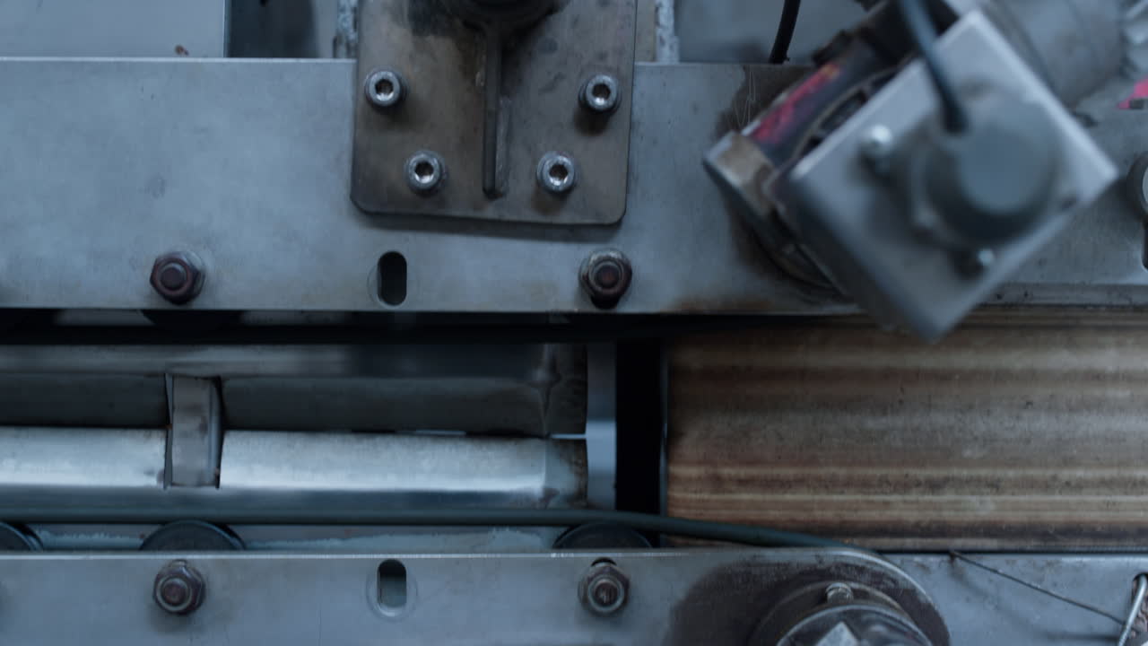 fotograma de cerca del transportador automático de la fábrica con piezas metálicas en la instalación de fabricación