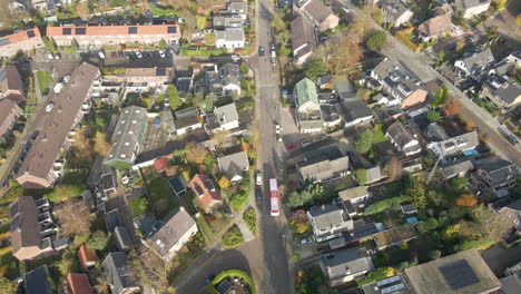 aerial of bus driving through a suburban neighborhood and stopping