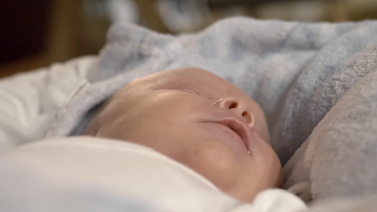 Closeup newborn baby boy sleeping comfortably wrapped in blanket