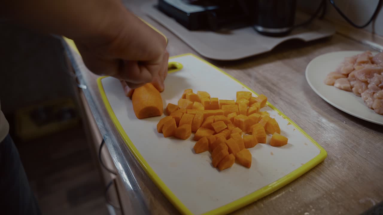 hombre cortando verduras a mano. vista de cerca de un hombre cortando zanahorias a mano en la tabla de cortar. nutrición orgánica. preparar una comida sabrosa. cocina de alimentos y concepto de personas. cocina de comida saludable en casa.