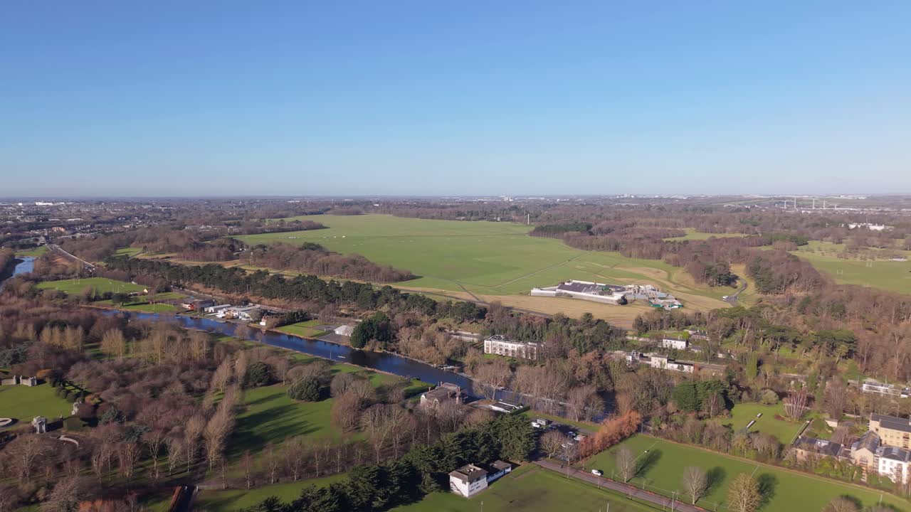 Phoenix park, dublin, showing vast green fields, trees, and a river, aerial view