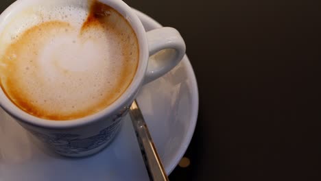 fotografía en primer plano de un capuchino con espuma cremosa y tonos cálidos de café