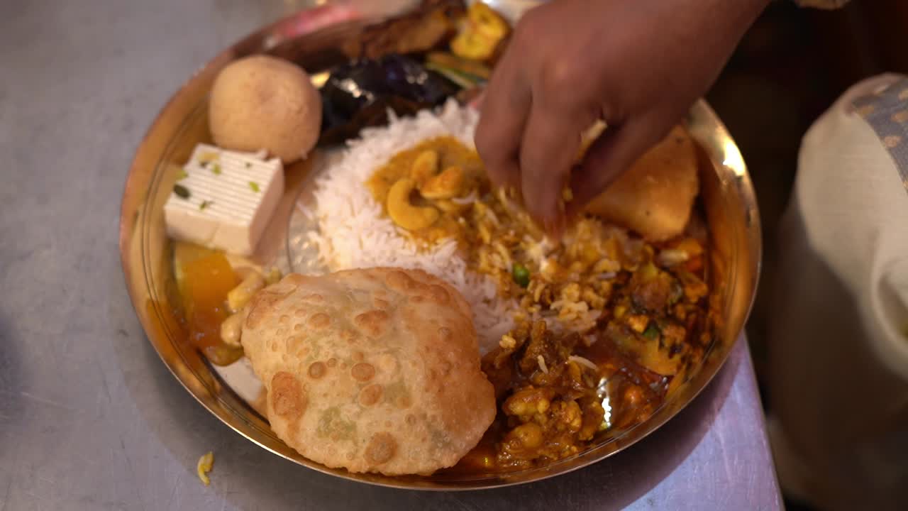 aplastamiento de platos tradicionales bengalíes con la mano para servir a los niños durante la comida festiva de annoprashan o pooja