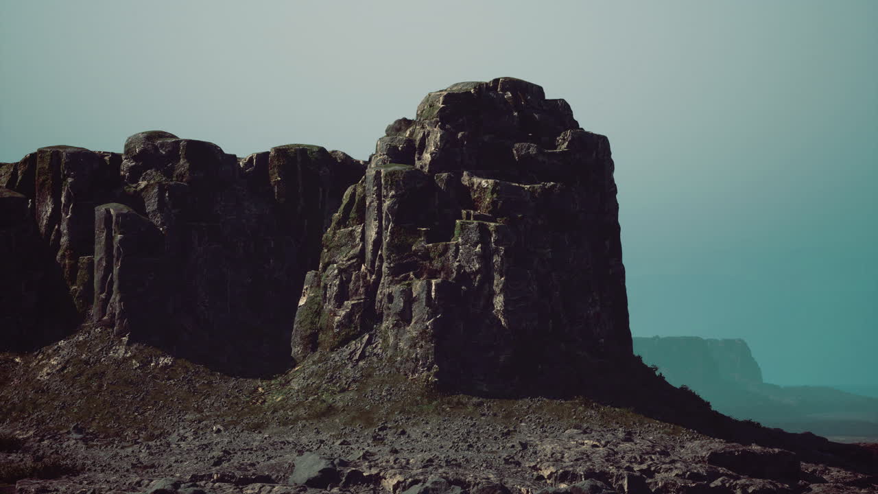 Majestic rock formations rise under a serene sky in a remote landscape