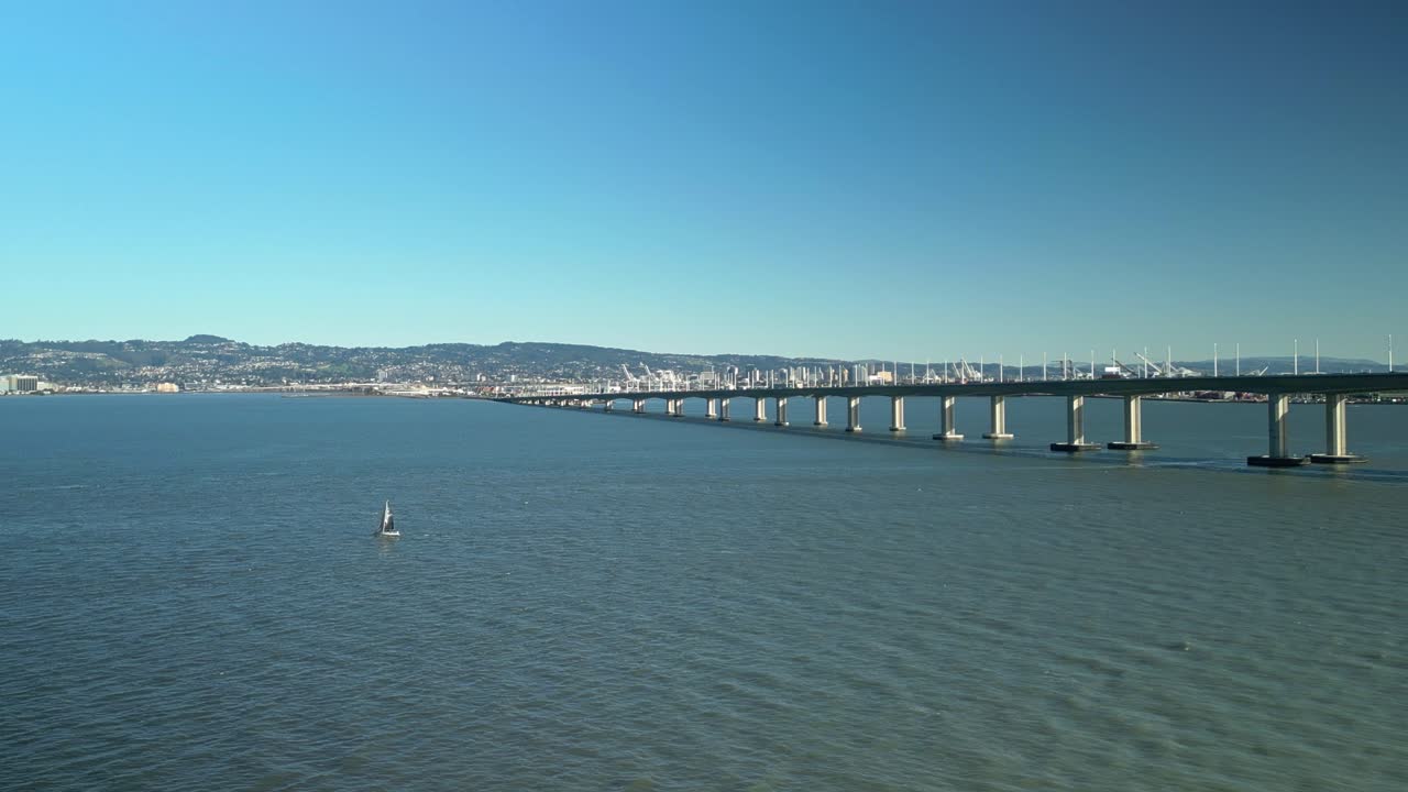 Pan drone shot of all the San Francisco-Oakland Bay Bridge with blue sky in California, USA