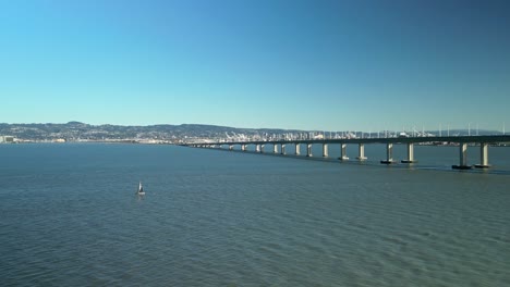 pan drone shot of all the san francisco-oakland bay bridge with blue sky in california, usa
