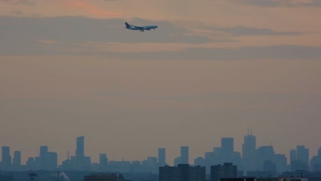 Avión-Comercial-Llegando-A-Aterrizar-Con-El-Horizonte-De-La-Ciudad-De-Toronto-Al-Fondo-Al-Atardecer