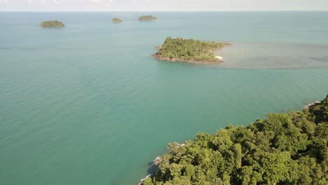 Aerial-fly-over-tropical-jungle-with-ocean-and-tropical-islands-in-distance