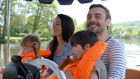 familie genießt einen tag im boot auf dem fluss, der langsam gedreht wurde