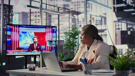 mujer trabajando en una oficina moderna viendo las noticias