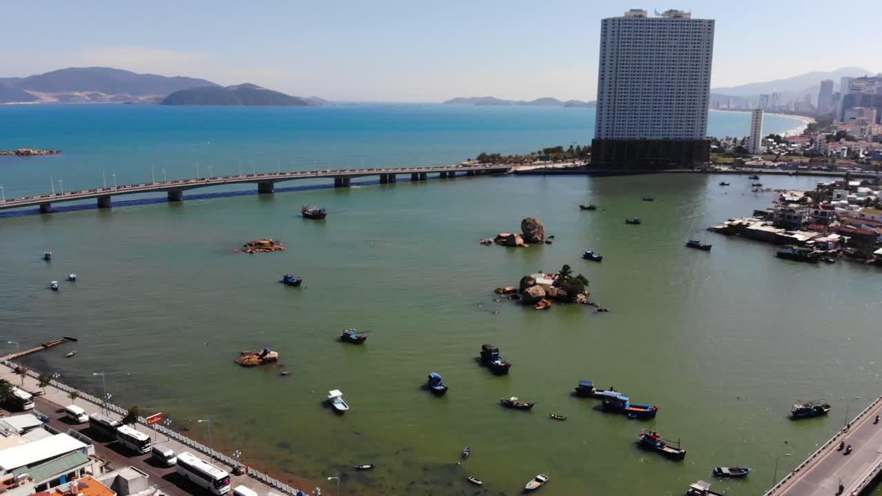 베트남의 화창한 날 배경에 도로 교량과 높은 도시 건물이 있는 나트랑 해변의 드론 뷰