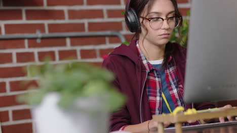 Joven-Mujer-De-Negocios-Caucásica-Pasante-Usando-Computadora-Navegando-En-Línea-Trabajando-Mecanografiando-Proyecto-De-Investigación-Para-Una-Empresa-De-Nueva-Creación-Generando-Ideas-Creativas-Escuchando-Música-En-Una-Oficina-Moderna-Y-Moderna