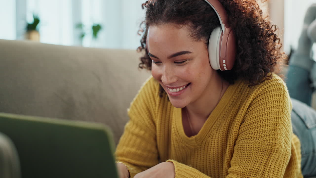 Woman using laptop with headphones on the couch