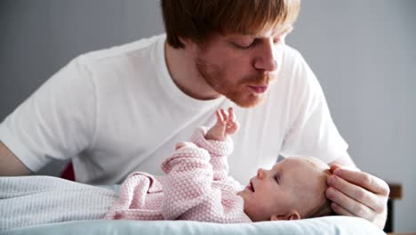 acariciando al padre calmando y besando a la hija bebé