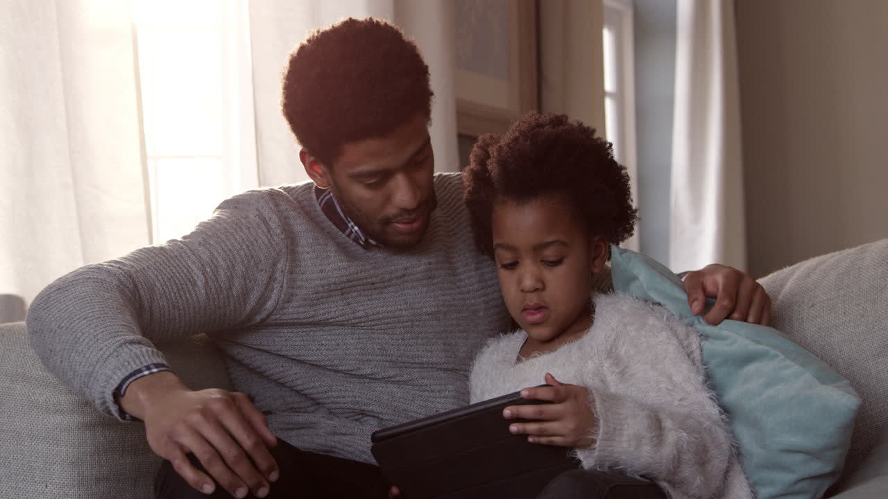 Father And Daughter On Sofa With Digital Tablet Shot On R3D