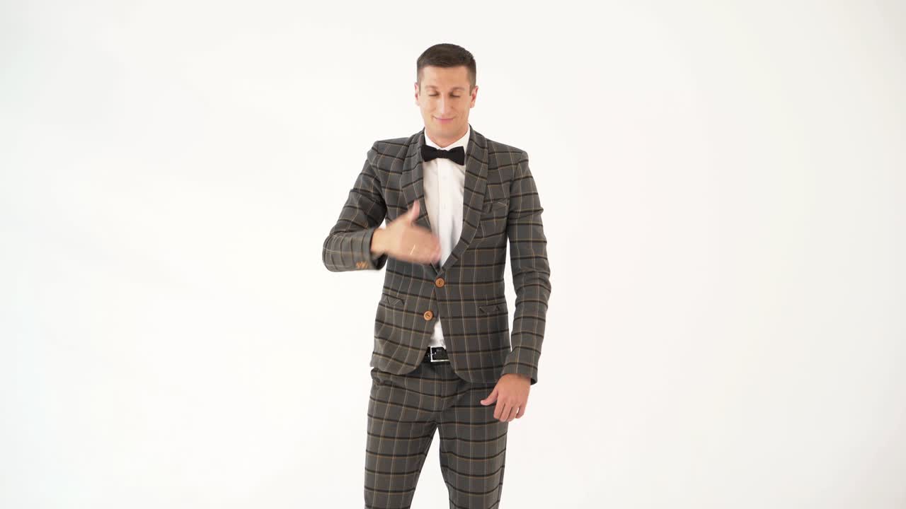 talented showman is holding his hand in front of his face and showing sad and funny emotions with his face in a white background