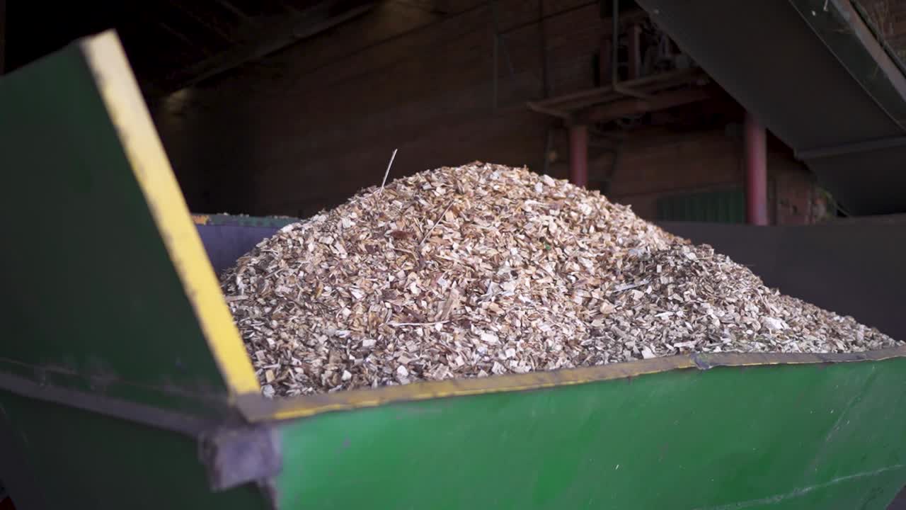 Pile of wood chips used as biomass fuel in an industrial container at a yerba mate drying facility in Misiones, Argentina