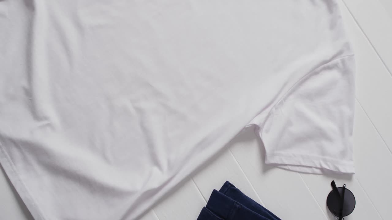 Video of flat lay of white t shirt with copy space on white background