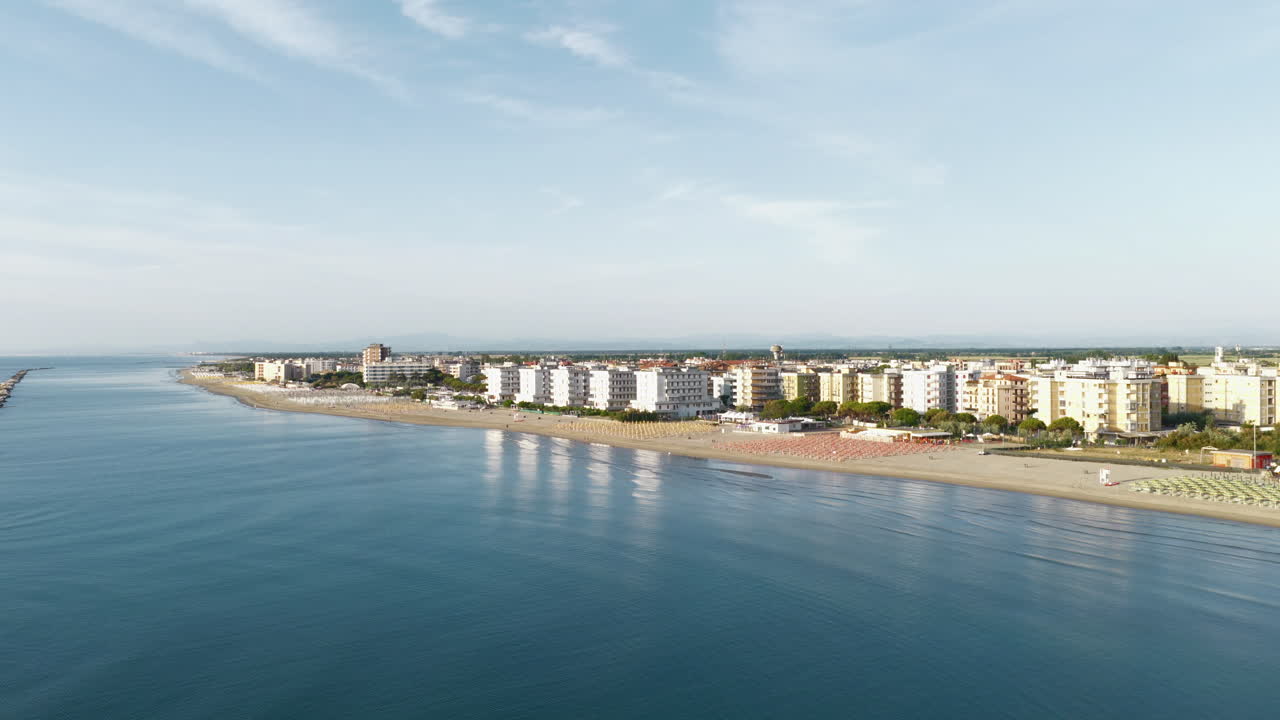 Drone view of sandy beach with umbrellas and gazebos.Summer vacation concept.Lido Adriano town,Adriatic coast, Emilia Romagna,Italy.