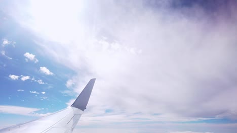 airplane view looking at the wing then pan towards the sky
