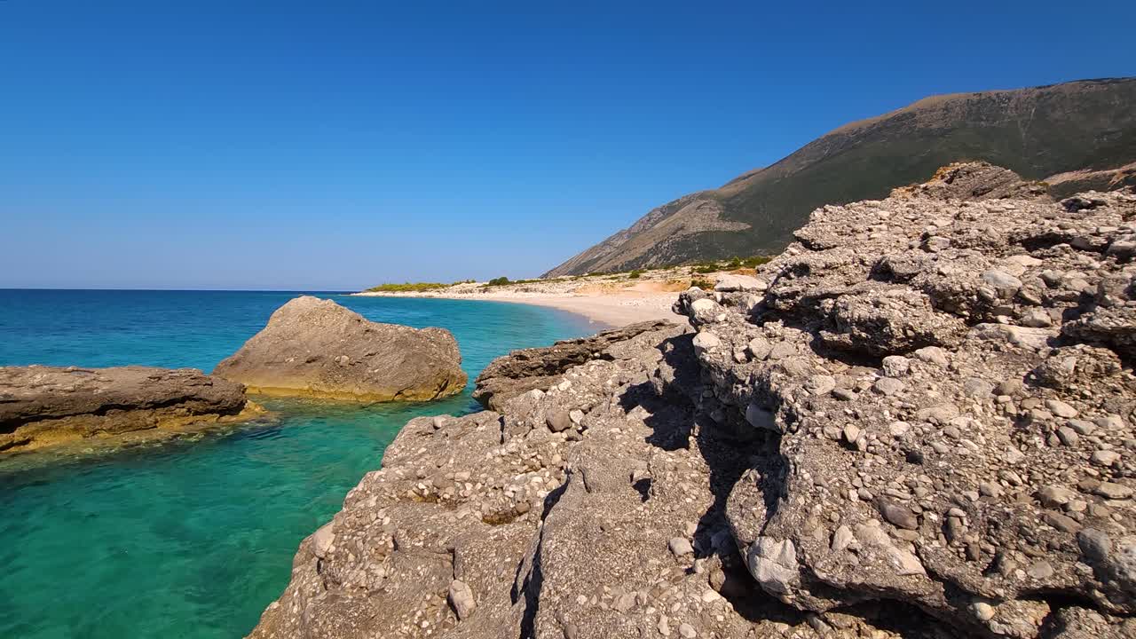 una playa secreta oculta atrae detrás de las rocas, lavada por las aguas azules del encantador mar jónico en albania