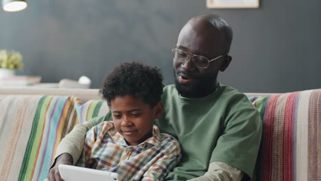 Alegre-Niño-Afroamericano-Jugando-Con-Papá-En-Una-Tableta-Digital-En-Casa