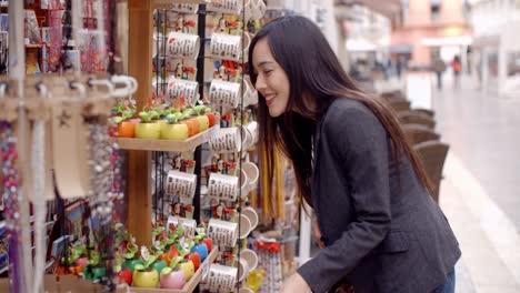 Mujer-Joven-Sonriente-Revisando-La-Mercancía-De-La-Tienda.