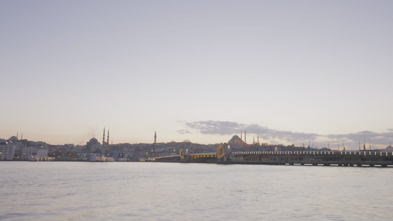 timelapse de barcos que navegan a estambul. acción. hermosa vista del puerto con barcos que pasan y puente en el fondo de la costa con mezquitas. costa con mezcitas en el fondo del crepúsculo