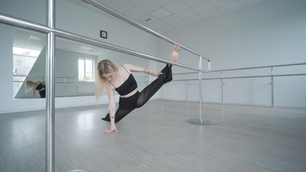 흑색 옷을 입은 소녀가 동시대를 선보이며, 여성 댄서가 하 방에서 흐르는 움직임, 몸과 손의 파동을 보여줍니다. 현대 발레 댄스 안무. 젊은 여성이 부드럽게 움직이고 있습니다.