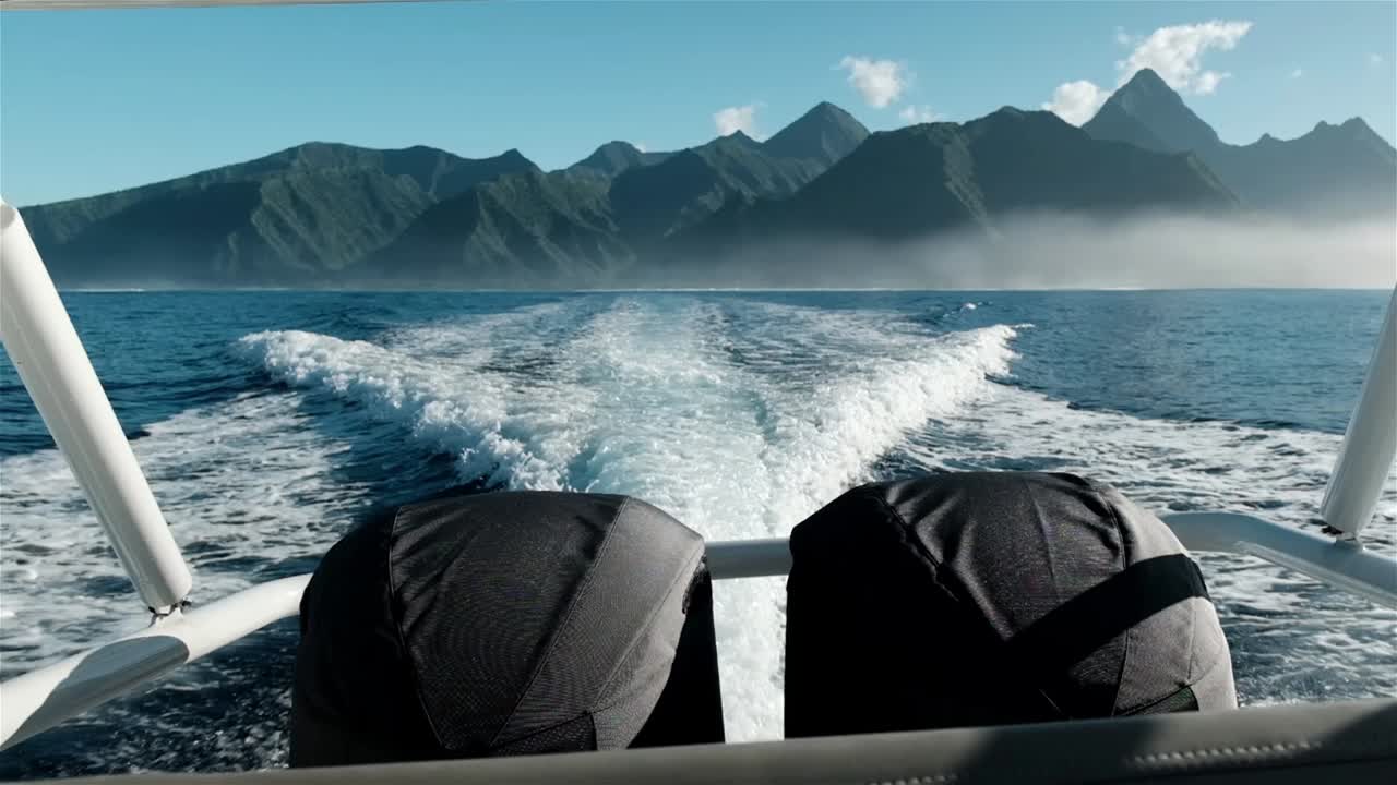 скоростная лодка с двумя обнимающими внешними двигателями в пути с впечатляющими горами таити на горизонте