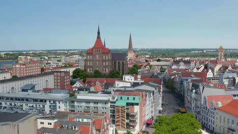 Aerial-view-of-old-town,-forwards-fly-to-Saint-Mary-church.-Large-brick-gothic-religious-building