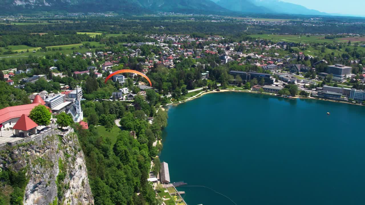 vista aérea sobre el lago bled en eslovenia con parapente volando sobre él