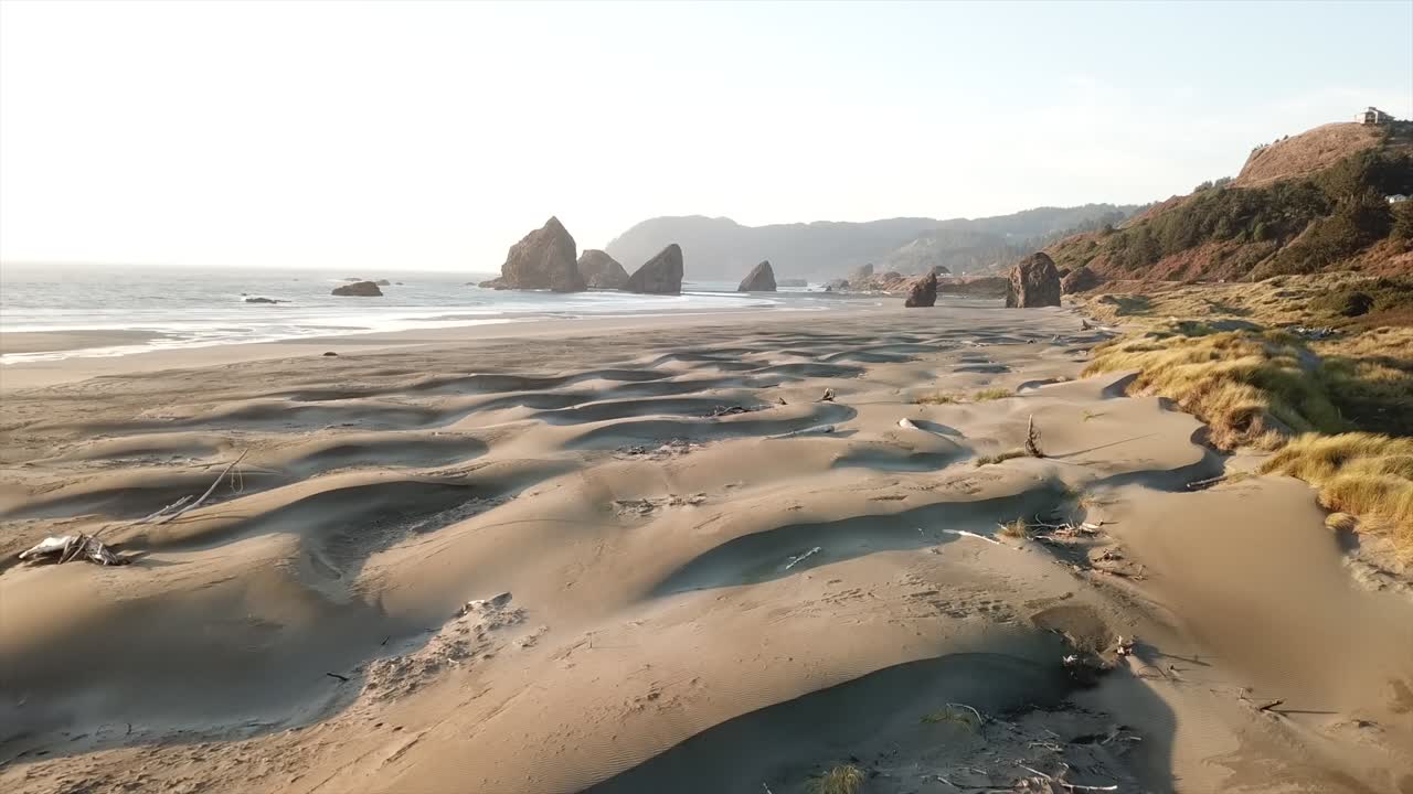 A drone shot of the Oregon coast highlighting the sand dunes and rock formations