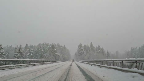 car driving on winter day during heavy snowfall, driver point of view shot, pov